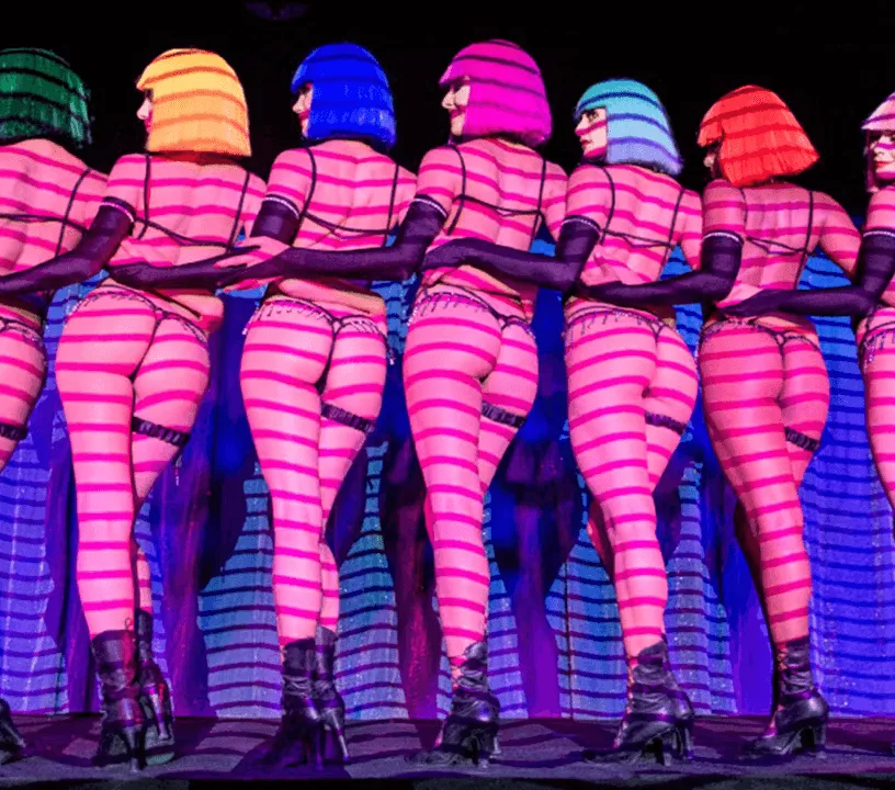Crazy Horse dancers under striped pink stage lighting