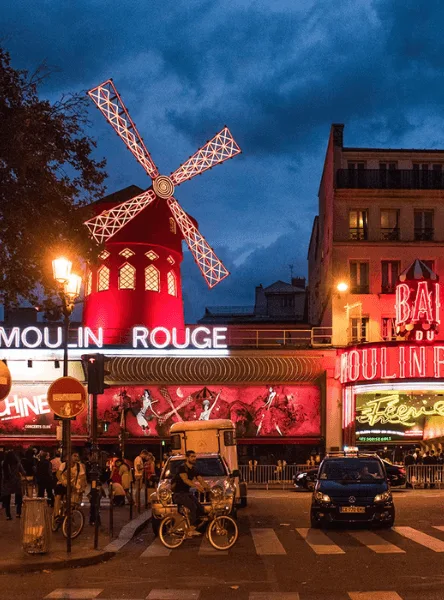 The illuminated red windmill outside Moulin Rouge at night