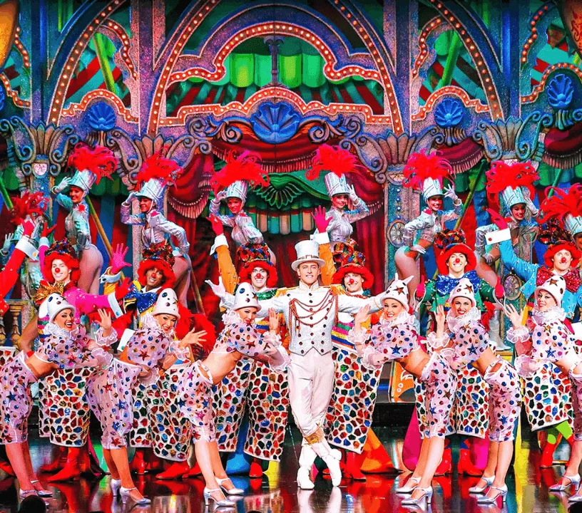 Moulin Rouge performers wearing colourful feather costumes